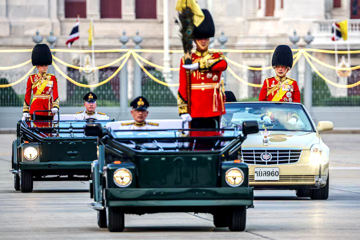 Thailand’s King Maha Vajiralongkorn and Queen Suthida review the guard of honour during a trooping of the colours ceremony to mark the 72nd birthday of Thailand’s King Maha Vajiralongkorn